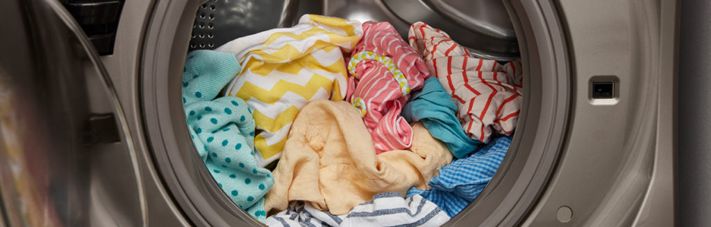 machine à laver ouverte avec des vêtements aux couleurs vives