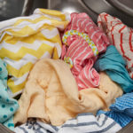 machine à laver ouverte avec des vêtements aux couleurs vives